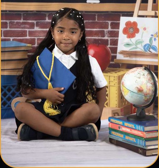 Niña con toga azul sentada entre libros
